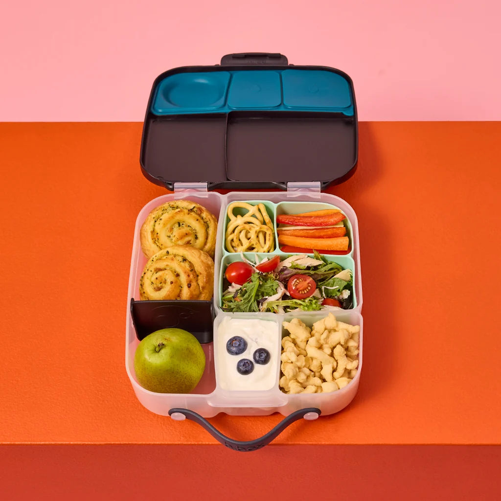 Bento box  lifestyle shots with bbox silicone lunchbox divider filled with various food items on a pink and orange background