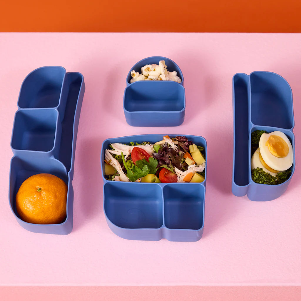 Ocean bento box silicon food divider set with compartments containing food on a pink background