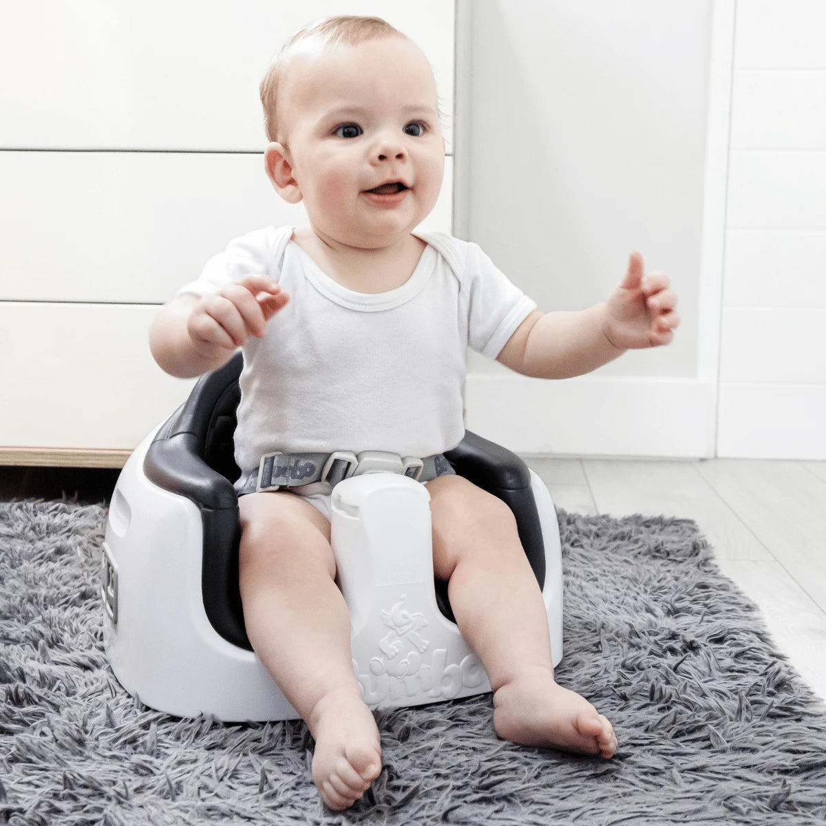 Baby sitting in a Cool Grey Bumbo 3-in-1 Multi Seat