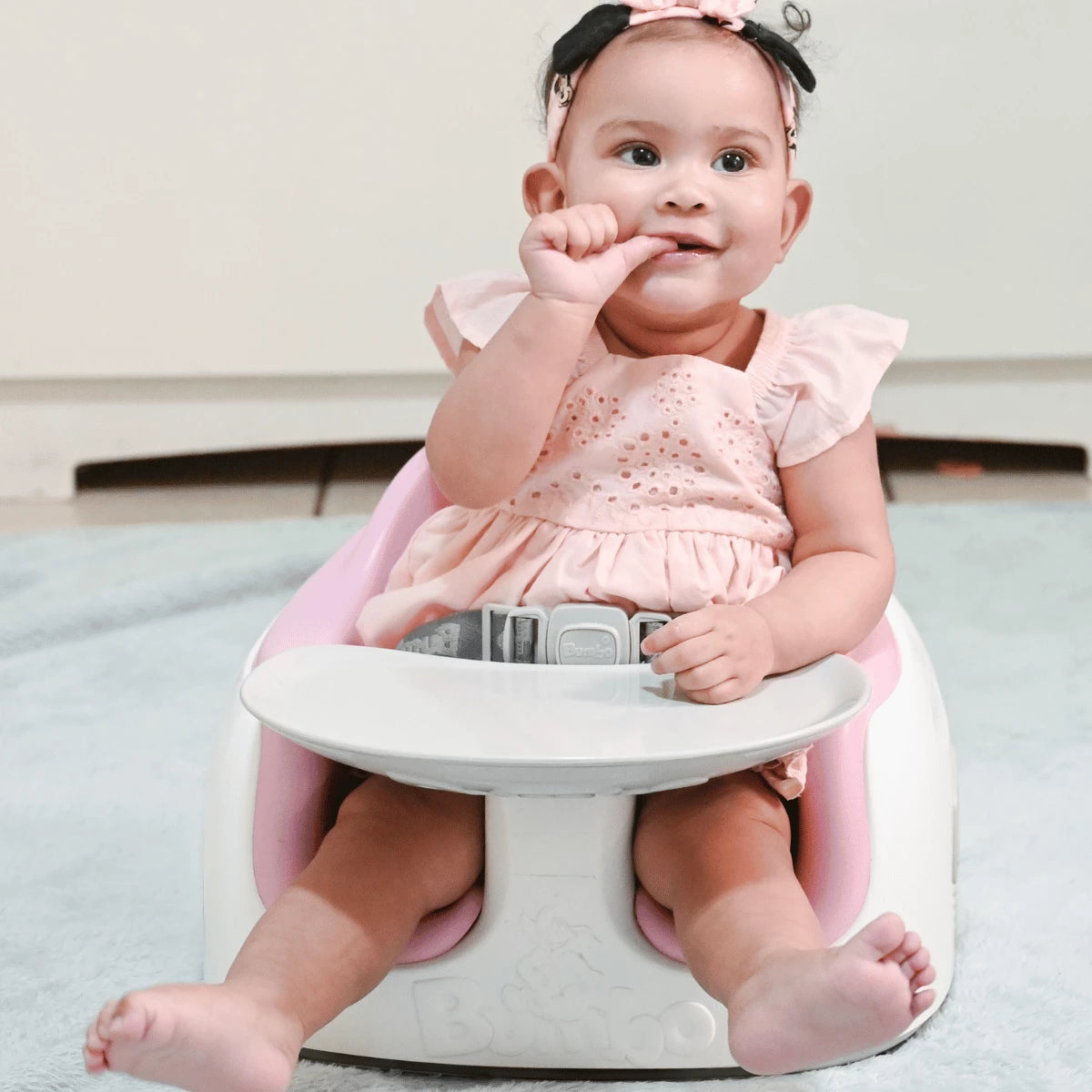 Baby sitting in a Cradle Pink Bumbo 3-in-1 Multi Seat with tray