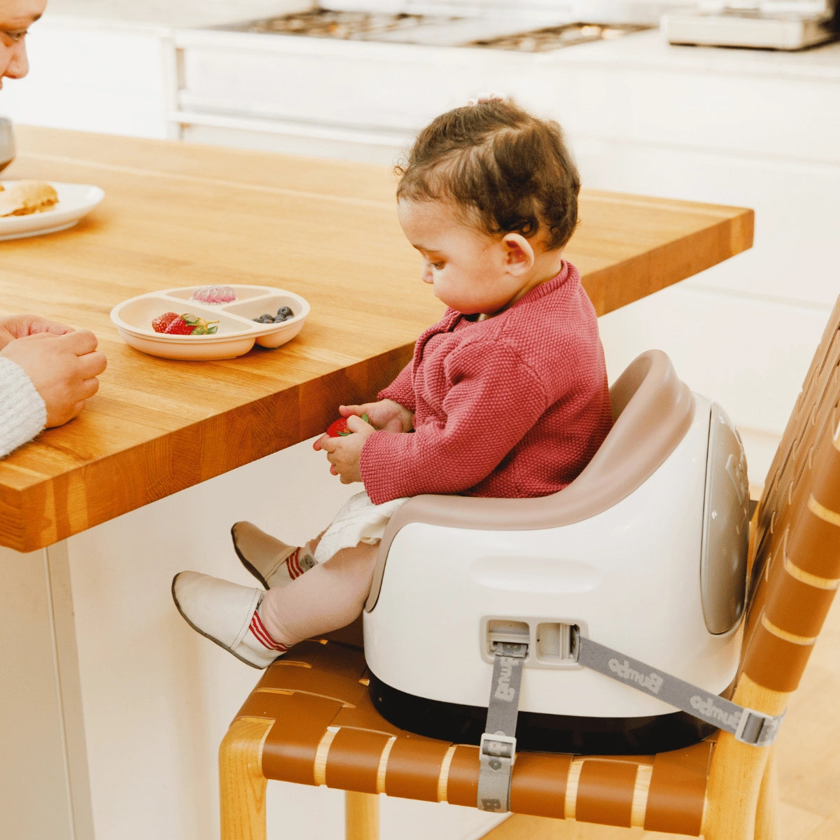 Toddler using a Taupe Bumbo 3-in-1 Multi Seat at the dining table