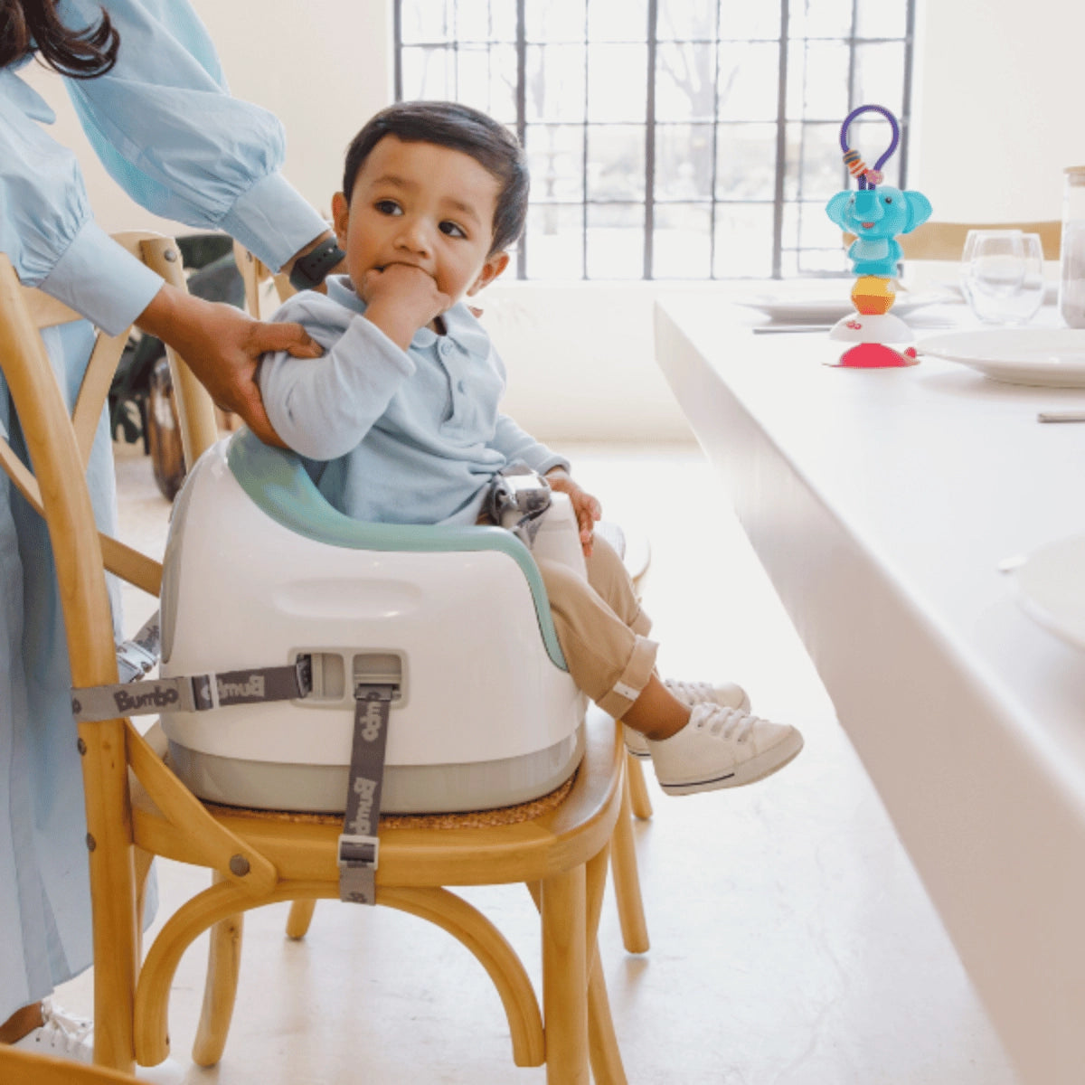 Baby seated in a Bumbo 3-in-1 Multi Seat secured to a dining chair